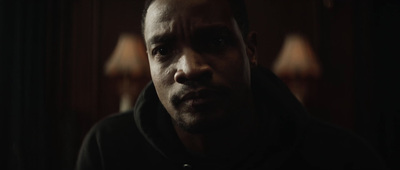 a man in a black hoodie staring at the camera