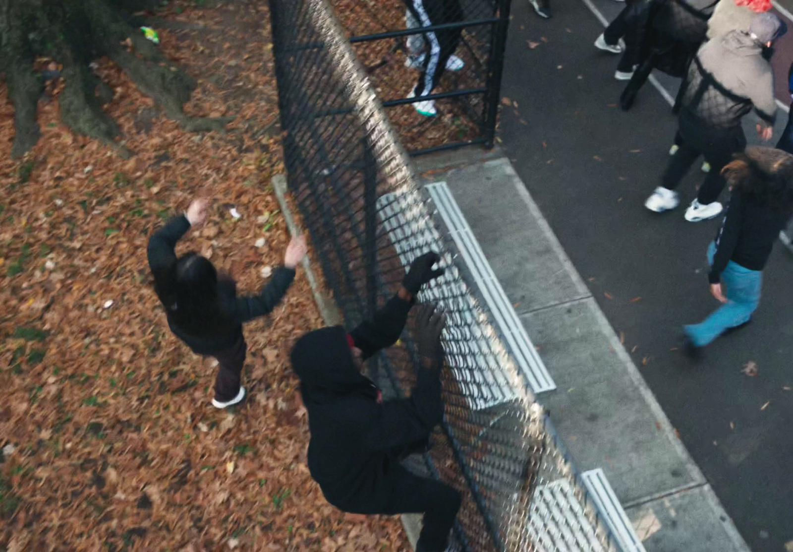 a group of people standing next to a fence