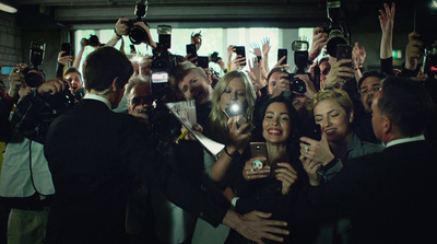 a group of people taking pictures with their cell phones