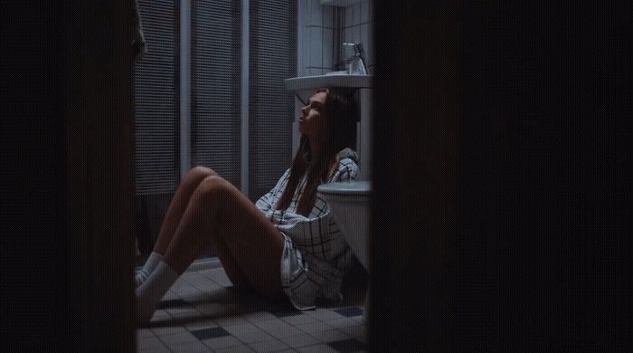 a woman sitting on a toilet in a bathroom