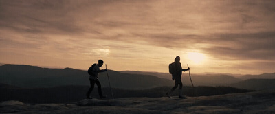 a couple of people standing on top of a mountain