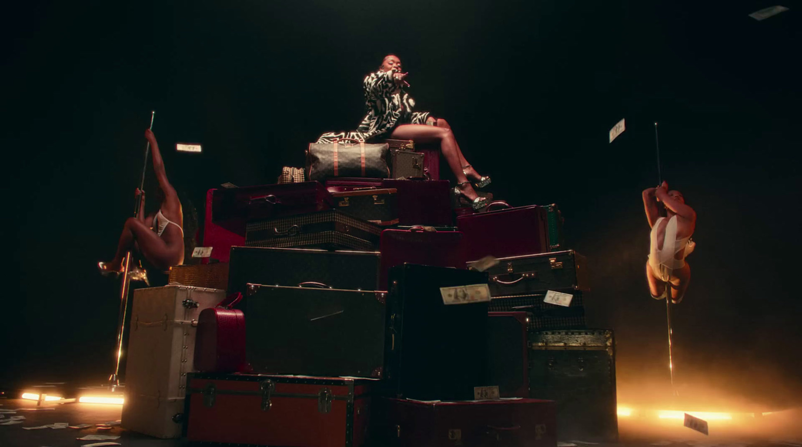 a woman sitting on top of a pile of luggage