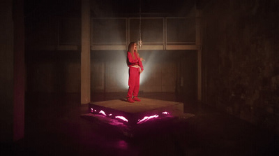 a woman in a red suit standing on a platform