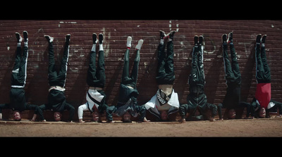 a group of people doing a handstand in front of a brick wall