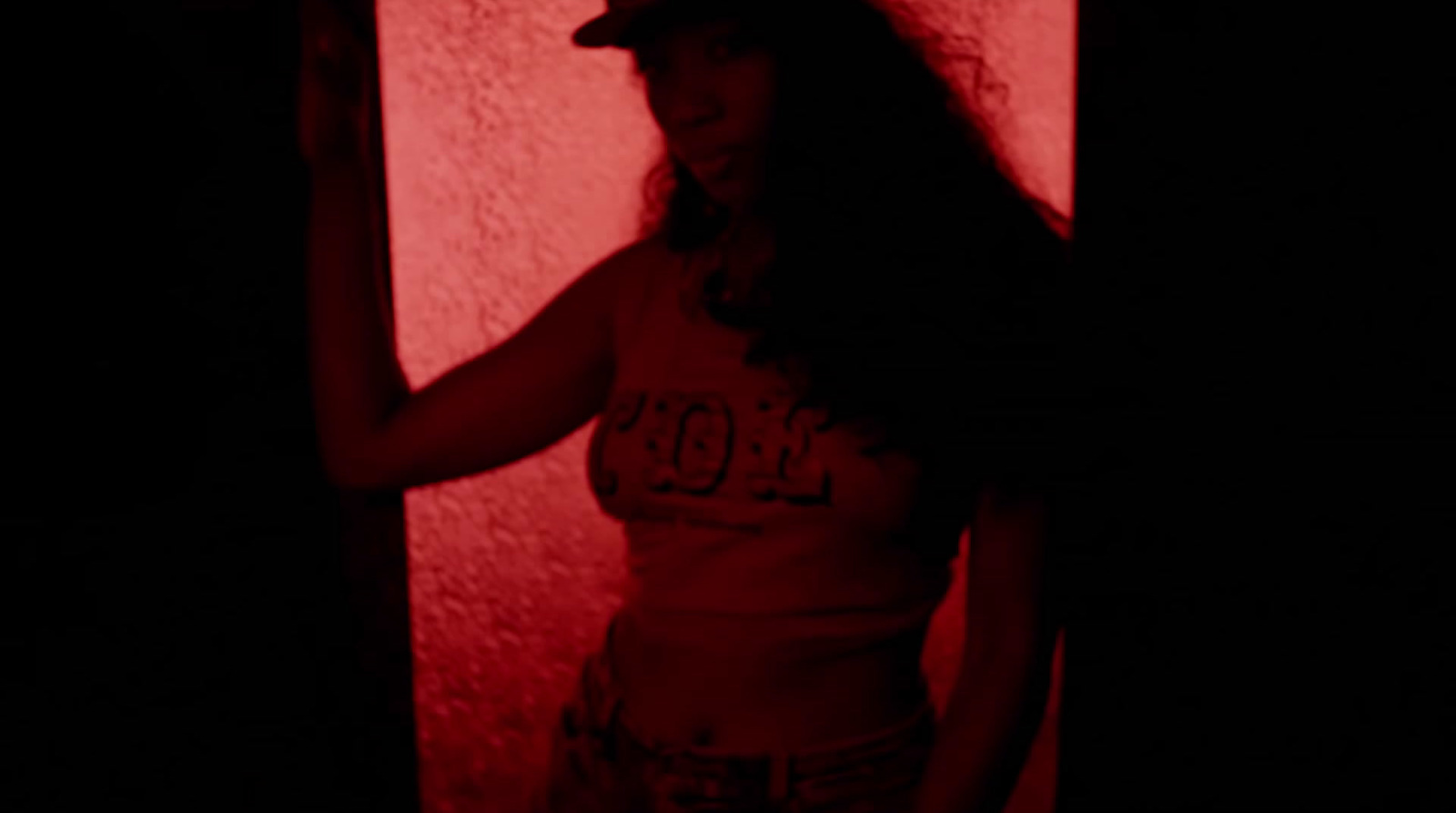 a woman standing in a dark room with a red light