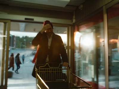 a man with a shopping cart talking on a cell phone