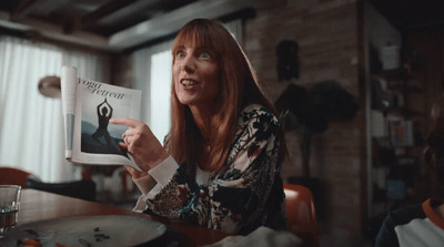 a woman sitting at a table reading a book