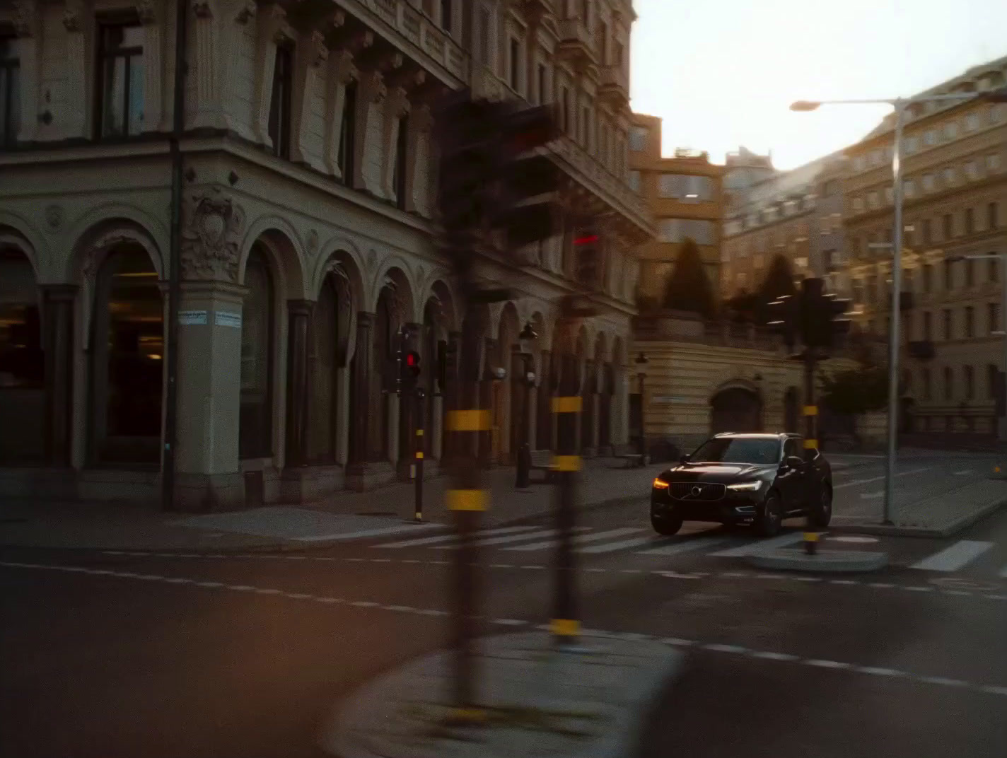 a car driving down a street next to tall buildings