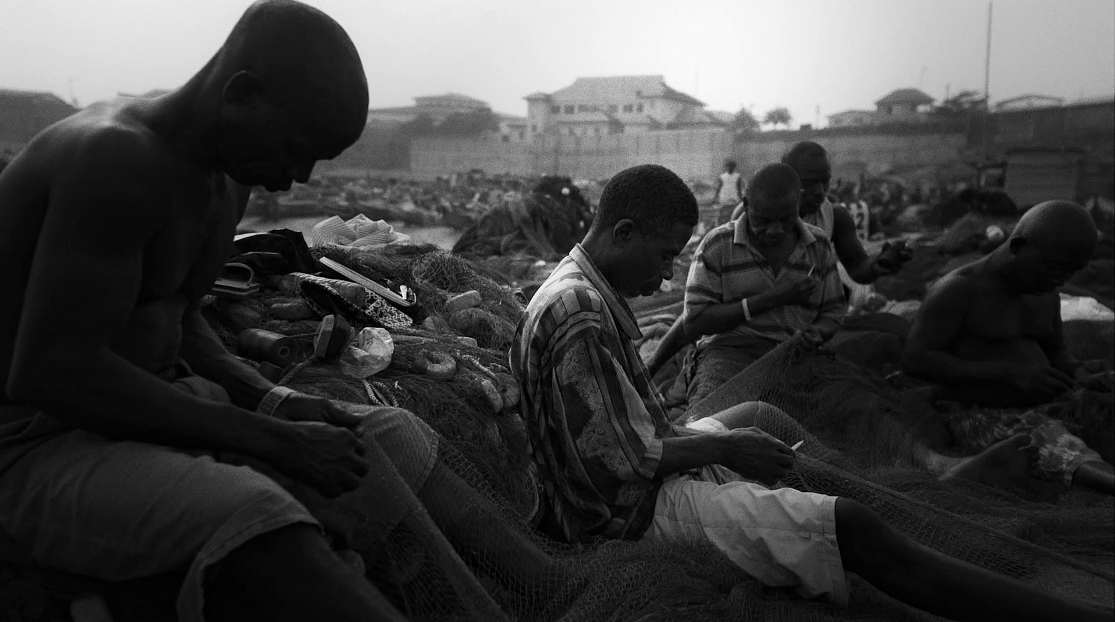 a group of men sitting on top of a beach