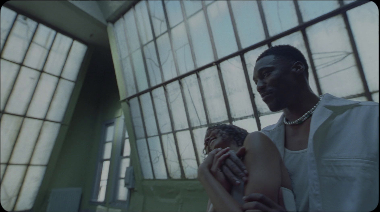 a man and a woman holding hands in front of a window