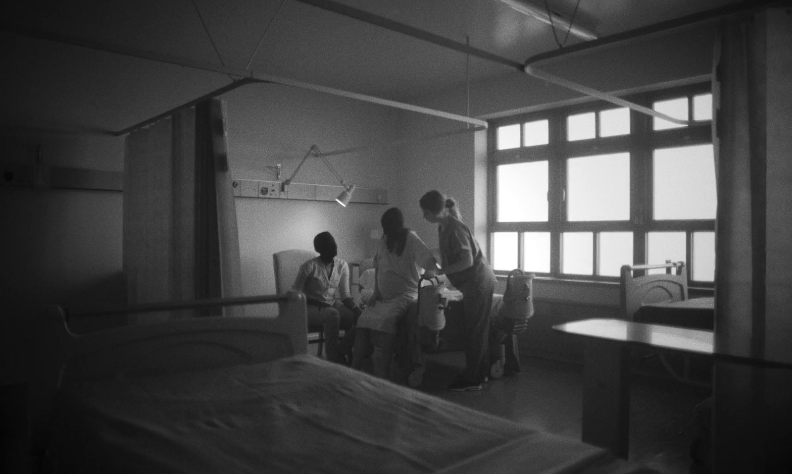 a group of people standing around a hospital bed