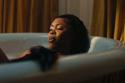 a woman laying in a bathtub with her eyes closed