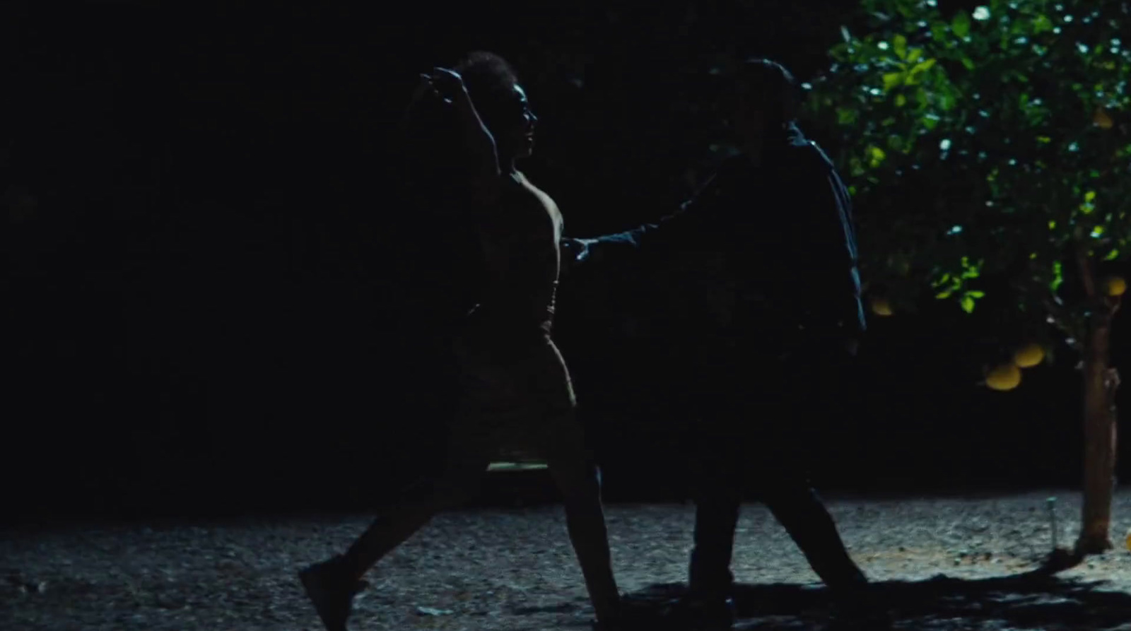 two people walking in the dark holding hands