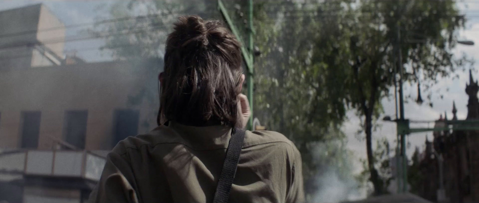 a person standing in front of a building with smoke coming out of it