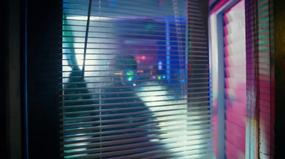 a person standing in front of a window covered in blinds