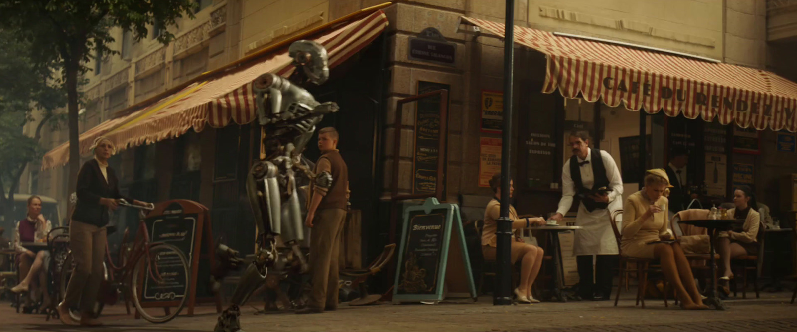 a group of people sitting at a table outside of a restaurant