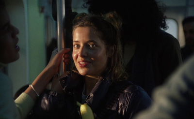 a woman is smiling while riding a bus