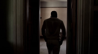 a man standing in a doorway in a dark room