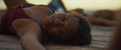 a woman in a red bikini laying on a wooden floor