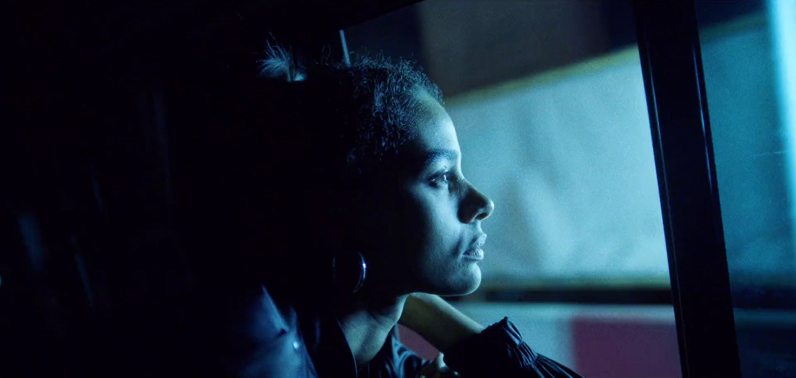 a woman sitting in a car looking out the window