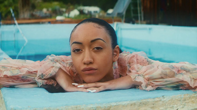 a woman in a pink dress laying in a pool