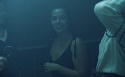 a woman standing next to a man in a dark room