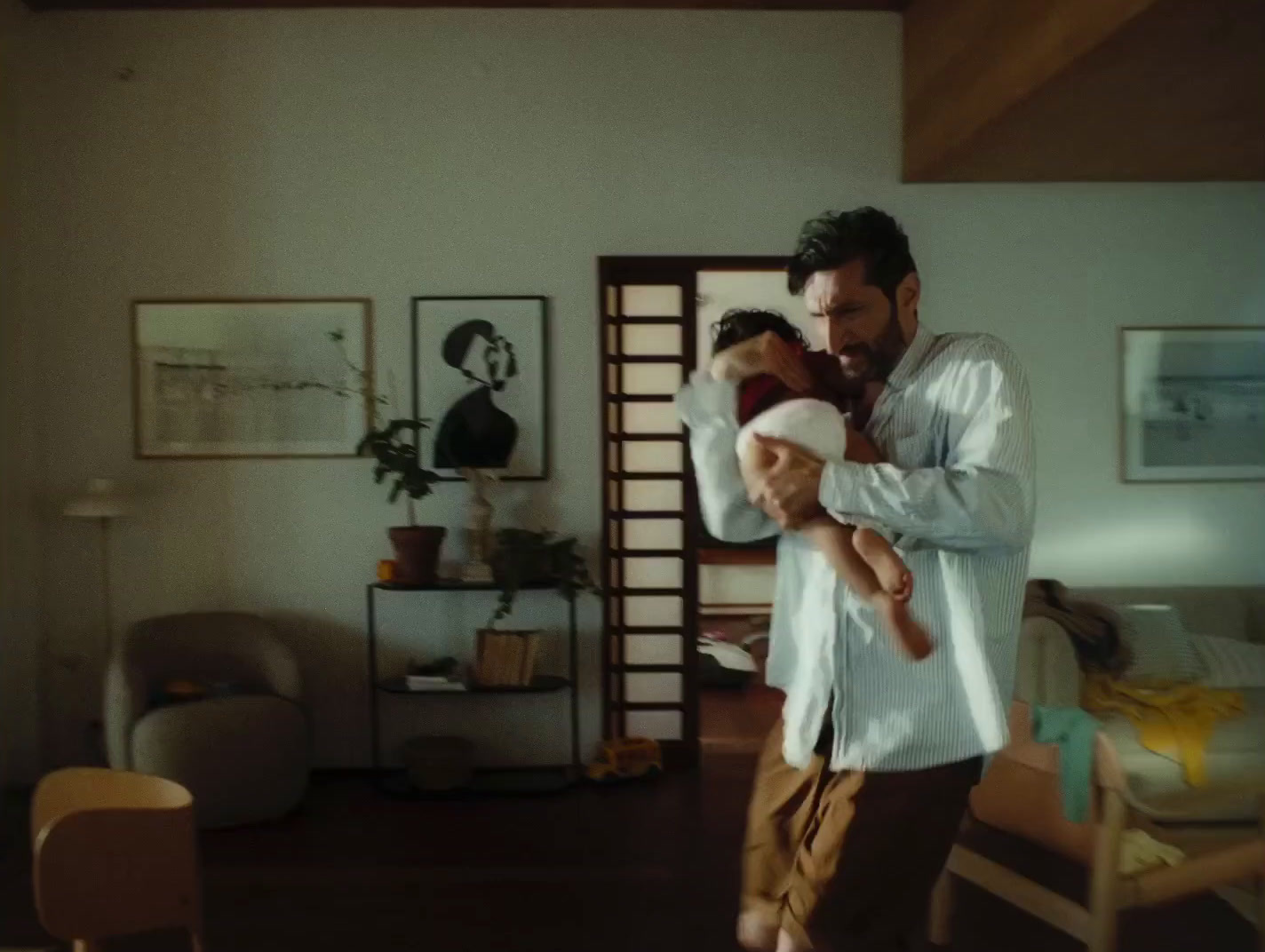 a man holding a baby in a living room