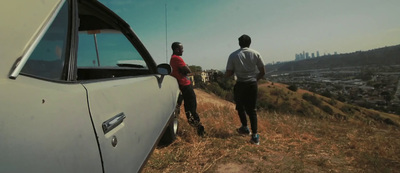 a couple of people standing next to a car