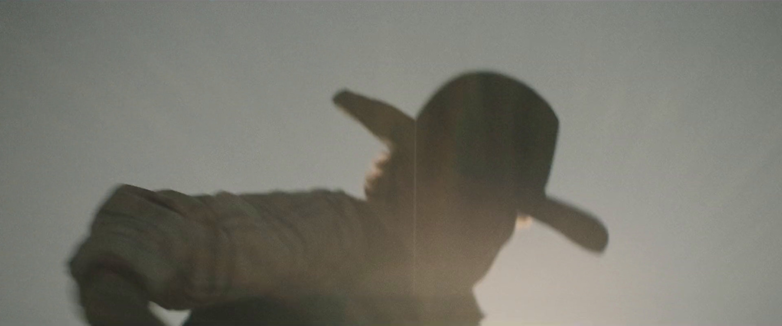 a blurry image of a person holding a hat