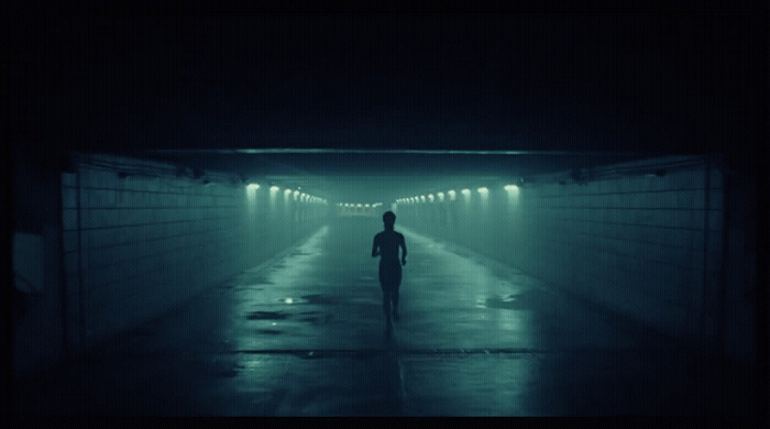 a man is walking in a dark tunnel