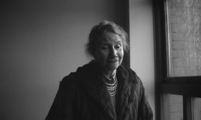 a woman standing next to a window in a room