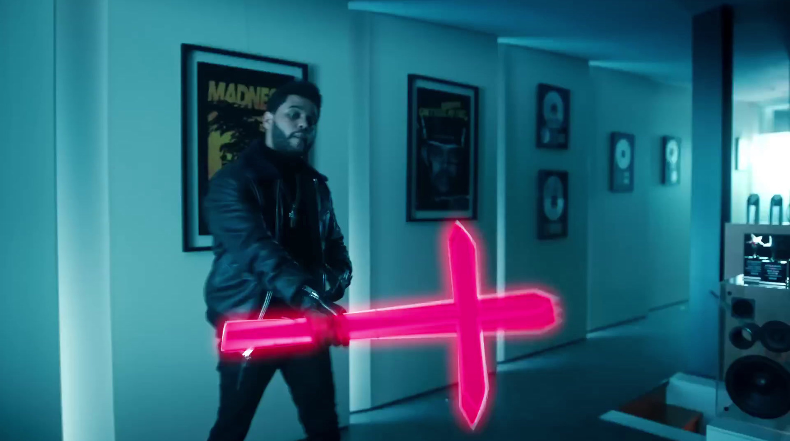 a man walking down a hallway holding a neon pink object