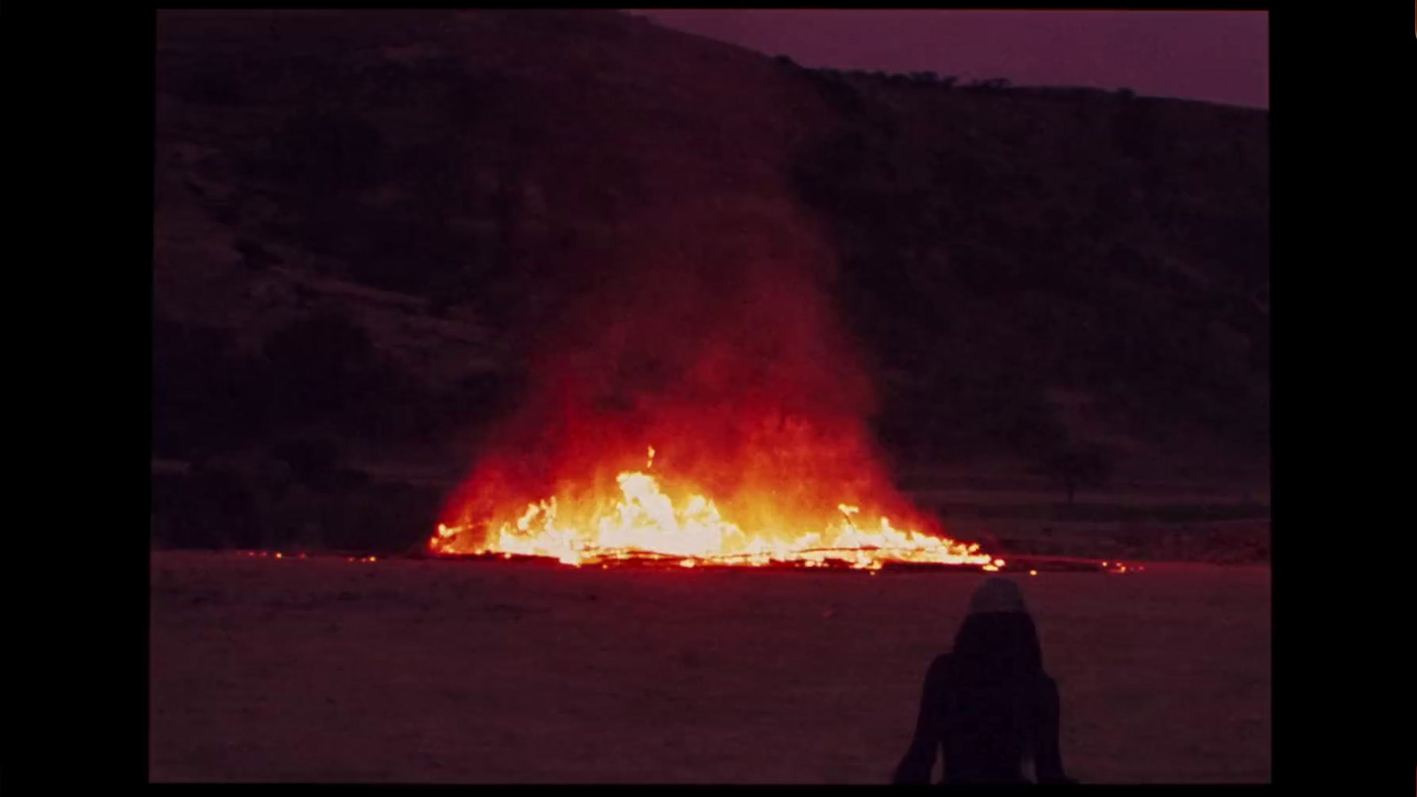 a person sitting in front of a fire