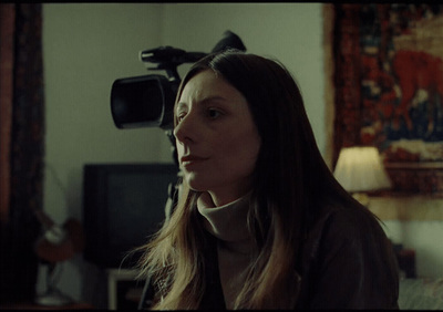 a woman with long hair standing in a living room