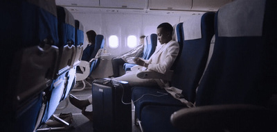 a man sitting on an airplane reading a book