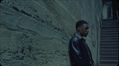 a man standing in front of a stone wall