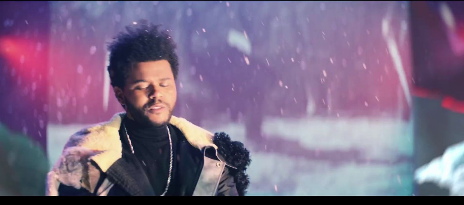 a man standing in the snow with his eyes closed