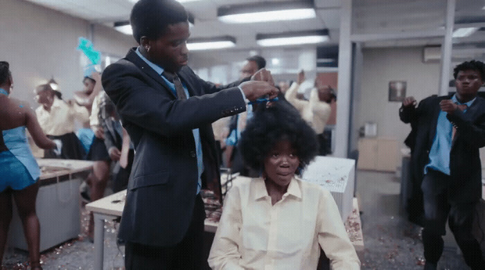 a man cutting a woman's hair in an office