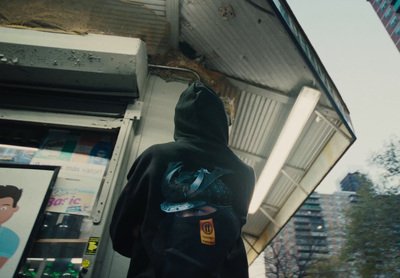 a person in a hoodie standing in front of a building