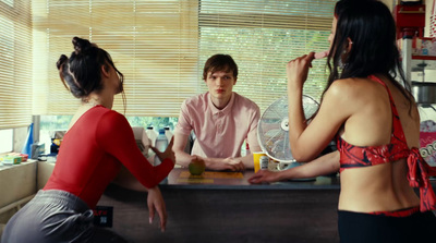 a woman sitting at a counter talking to a man