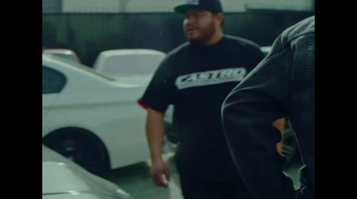 a man standing next to a white car in a garage