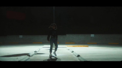 a person standing on a skateboard in a parking lot