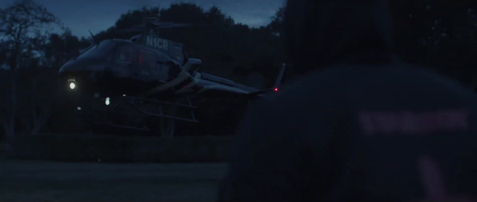 a person standing in front of a helicopter at night