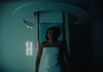 a woman laying in a bed in a dark room