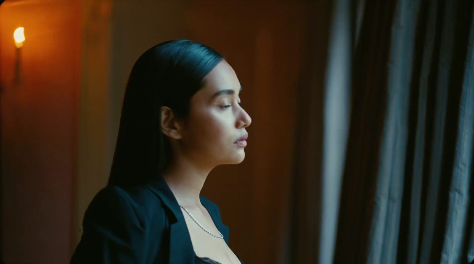 a woman looking out of a window in a dark room