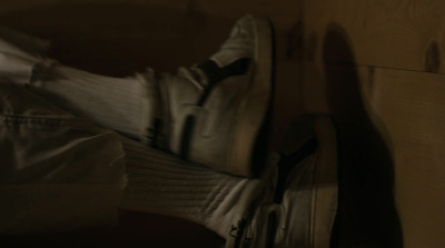 a pair of white shoes sitting on top of a wooden floor