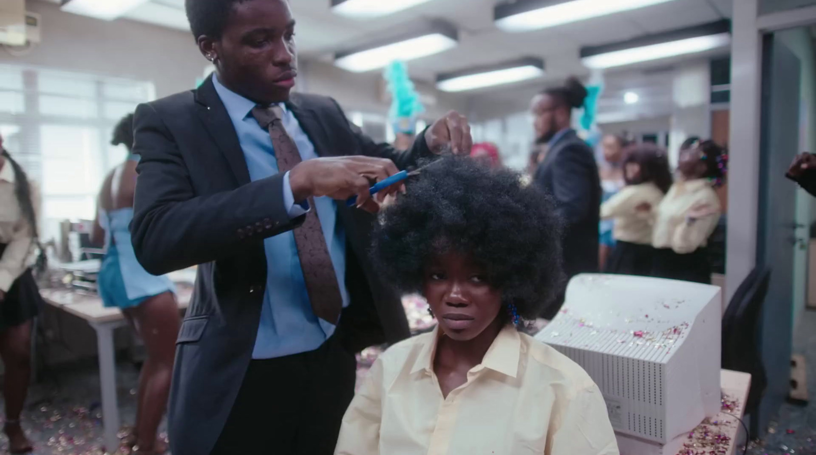 a man cutting a woman's hair in an office