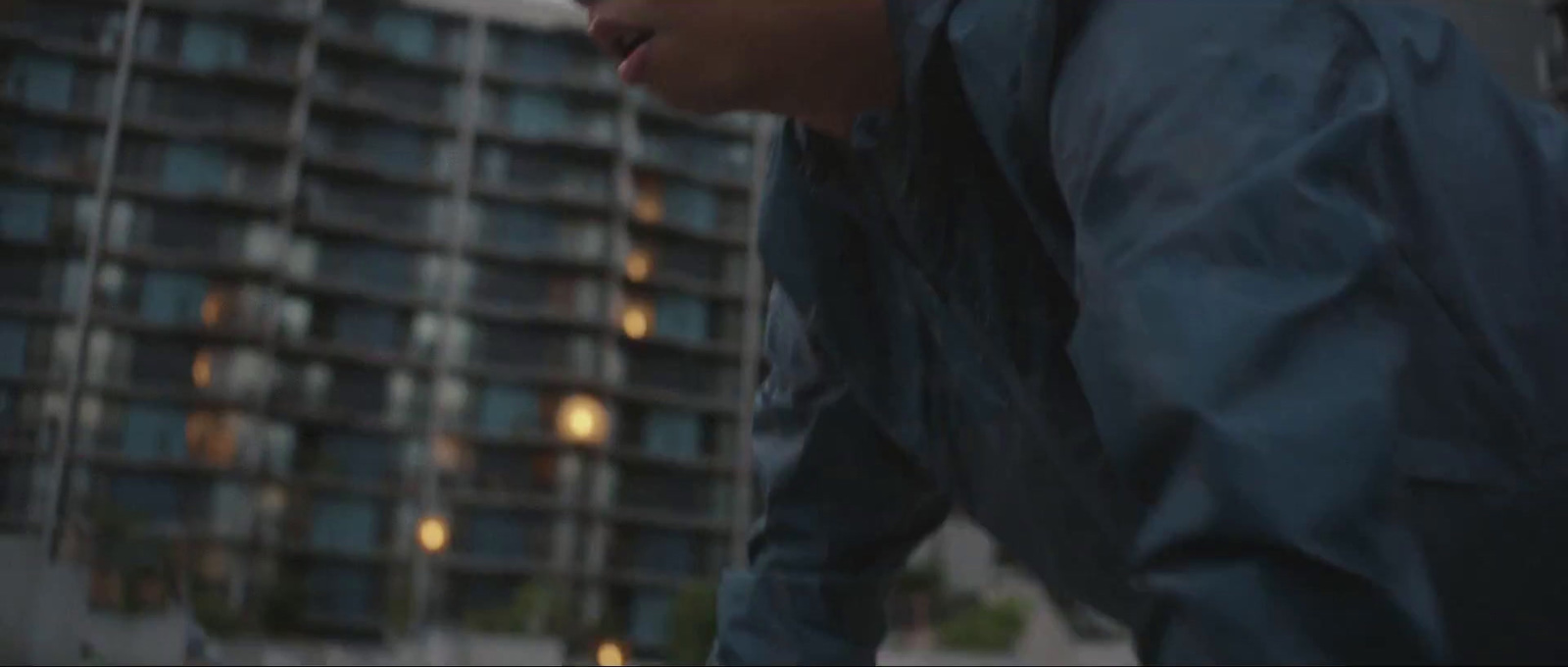 a man in a blue jacket looking down at his cell phone