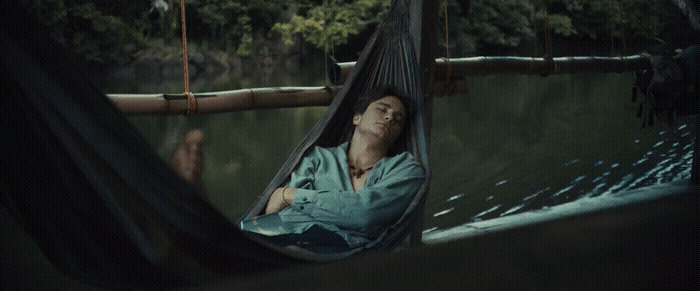 a man laying in a hammock in the water