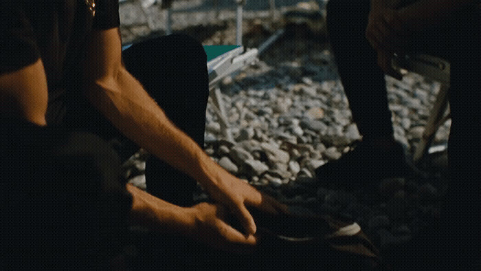 a man sitting on the ground tying his shoes